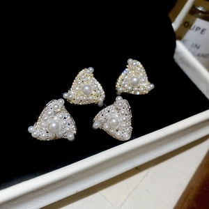 Detailed view of silver triangle pearl earrings with sparkling zircons in a jewelry box