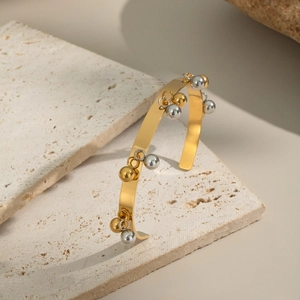 Bracciale rigido aperto lucido in oro 18K con ciondoli a sfera bicolore oro e argento