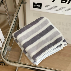 Close-up of thick striped coral fleece bath towel with white fabric binding edge