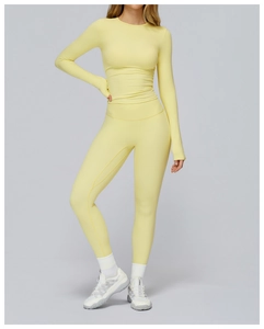 Detail of light yellow long sleeve yoga top with thumbholes and high waist leggings