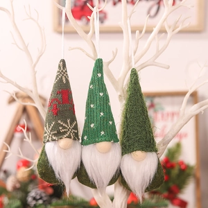Three-piece green knitted Christmas gnomes hanging ornaments on a white festive branch