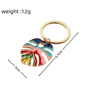 Detail view of colorful enamel monstera leaf keychain with measurements 12g and 6.5cm