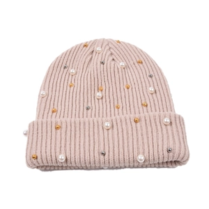 Dettaglio del berretto in maglia a coste con perle e perline metalliche rosa tenue