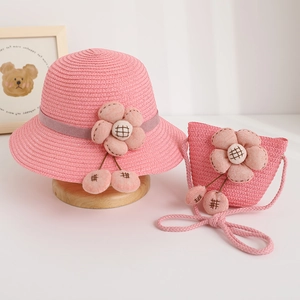 Detail of pink straw hat and matching bag set with 3D fabric flowers and checkered pendants