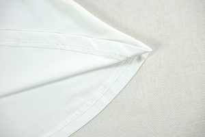Detailed view of the double stitching on the white mini dress hem and knit fabric texture