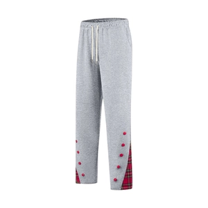 Détail du pantalon de jogging gris avec cordon blanc et empiècement à carreaux rouges