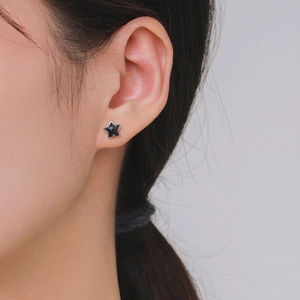 S925 sterling silver stud earrings featuring a shimmering black obsidian star on model