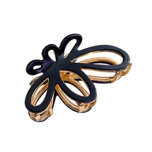 Elegant gold metal hollow butterfly hair claw clip with black finish on white background