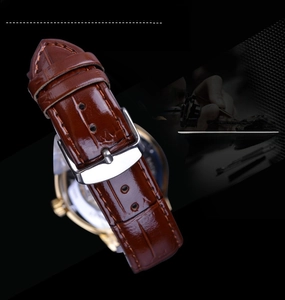Close-up of brown genuine leather watch strap with polished stainless steel buckle detail