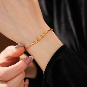 Close-up of 18K gold plated bamboo link bracelet with zircon inlaid hollow round beads