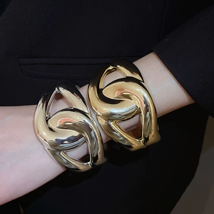 Detailed close-up of gold and silver chunky chain link bracelets on a fashion model