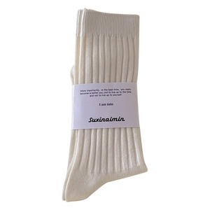 Classic white ribbed crew socks for women featuring minimalist paper band packaging