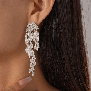 Detail of silver leaf drop earrings with sparkling rhinestones on a female model