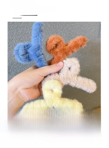Detail of four colorful plush hair claws in blue, orange, cream and yellow for autumn