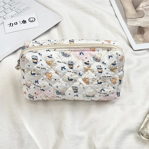 Detailed view of quilted makeup bag with cute puppy prints and top zipper closure