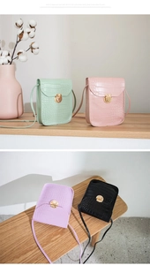 Detail view of mini crocodile pattern crossbody bags with golden rotary metal locks
