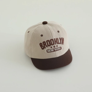 Close-up of beige corduroy kids baseball cap featuring brown Brooklyn embroidery detail
