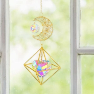 Close-up of golden moon suncatcher with prismatic AB heart crystal and geometric frame