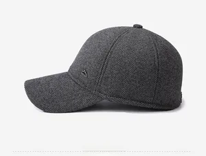 Side view of winter wool baseball cap with grey herringbone texture and metal mountain logo