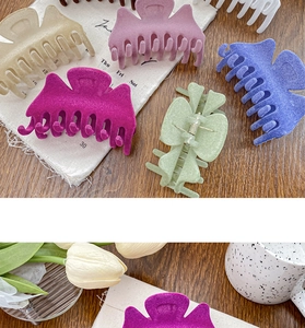 Détail de pinces à cheveux en velours et mates de différentes couleurs sur une table