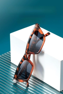 Detail of tortoise shell cat-eye sunglasses with dark lenses on a modern podium