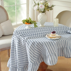 Detail of blue and white striped round tablecloth with elegant ruffled edge design