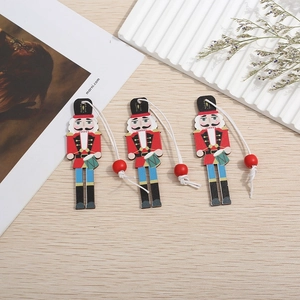 Three wooden nutcracker soldier ornaments with red beads and ropes for Christmas tree decor