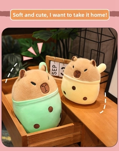 Close-up of cute mint green and yellow capybara plush toys in a cozy wooden drawer