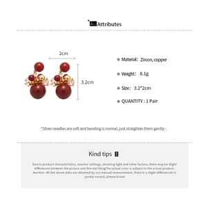 Detail view of red zircon drop earrings with size specs and copper silver needles