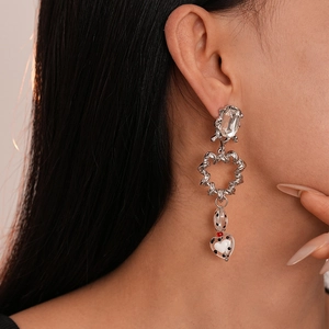 Detail of silver drop earring with rhinestone stud and black white polka dot heart bead