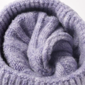Close-up of purple knit beanie showing thick jacquard texture and fuzzy mohair yarn details
