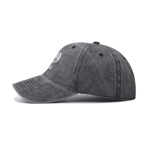 Detail of white Paris embroidery and washed cotton texture on dark gray baseball cap