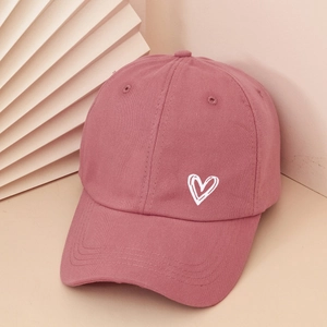 Detail of dusty rose cotton baseball cap featuring white heart embroidery and twill texture