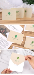 Macro view of matte greeting cards with green leaf illustrations and matching envelopes