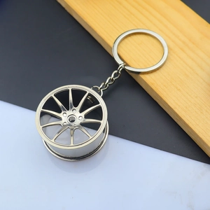 Detailed close-up of a silver metal car wheel rim keychain with a multi-spoke design
