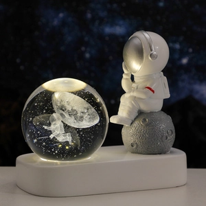 Luce notturna a sfera di cristallo astronauta con base a LED calda su sfondo cielo stellato
