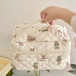 Detail of white quilted cotton makeup bag with cute teddy bear prints and carry handle