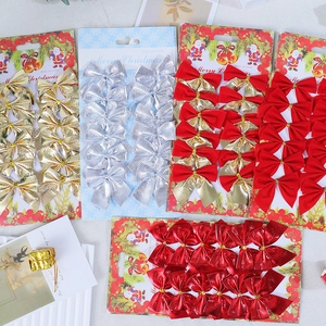 Flat lay of colorful Christmas bows in gold, silver, and red velvet on a white background