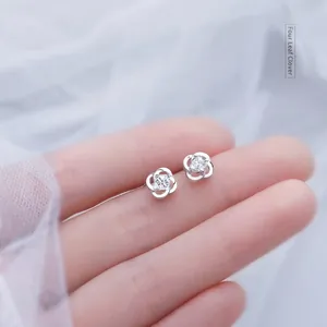 Elegant four-leaf clover silver stud earrings with sparkling center moissanite stone