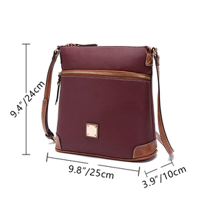 Detail view of burgundy pebble leather crossbody bag with brown trim and gold hardware