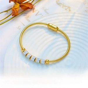 Detail of gold snake chain bracelet with five rhinestone beads and magnetic clasp