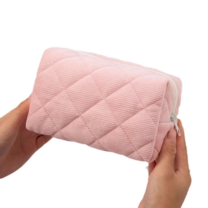Pink quilted corduroy cosmetic bag with lattice pattern and white zipper closure