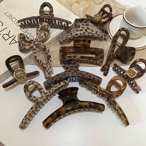 Macro shot of stylish tortoiseshell claw clips with leopard patterns on artistic books