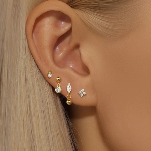 Macro shot of gold plated silver earring set featuring cubic zirconia studs and hoops