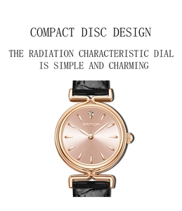 Detail of rose gold watch face with sunray texture, rhinestone index and black leather strap