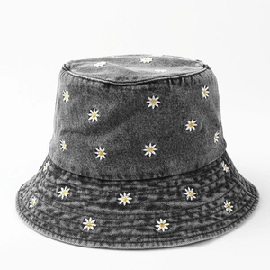 Faded grey denim bucket hat with white daisy floral embroidery and a wide sun brim