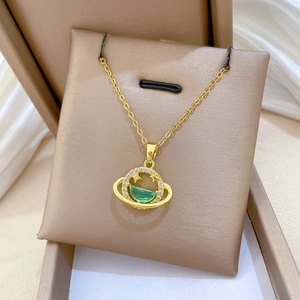 Detail of star galaxy planet pendant with green gemstone and zircons on gold chain