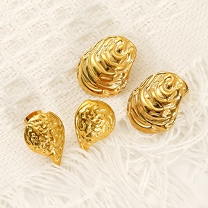 Irregular gold lava textured stainless steel stud earrings set on white fabric