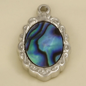 Macro detail of oval stainless steel pendant with iridescent blue-green abalone shell inlay