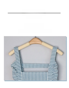 Detail of the H-shaped wide shoulder straps on a blue and white striped waterproof apron